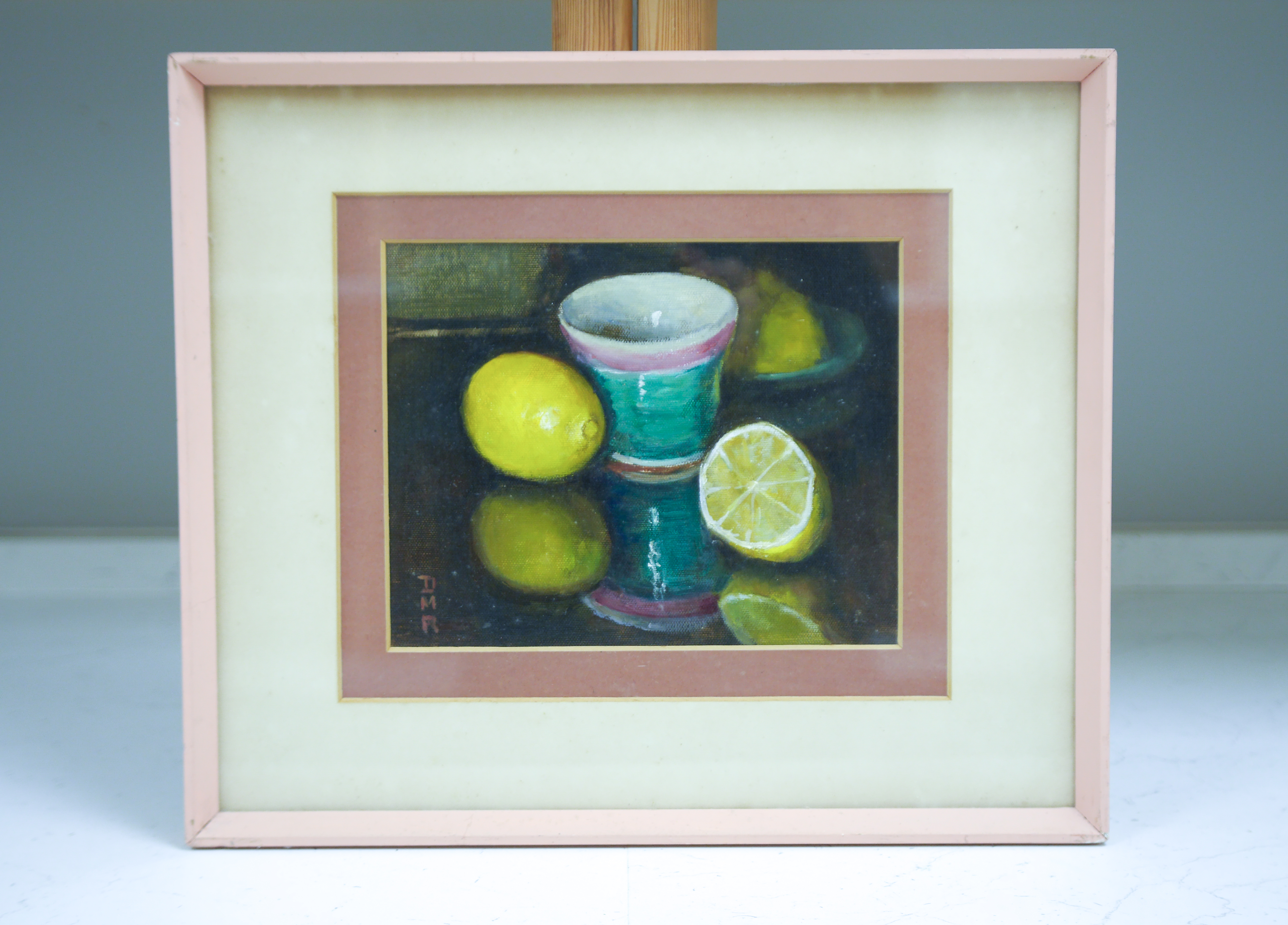 Modern British, oil on canvas board, Still life of lemons and vessels, monogrammed D.M.R., 19 x 24cm. Condition - good